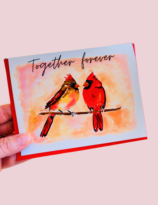 Whimsical cardinal couple greeting card with “Together Forever” phrase by artist Ingrid Jany