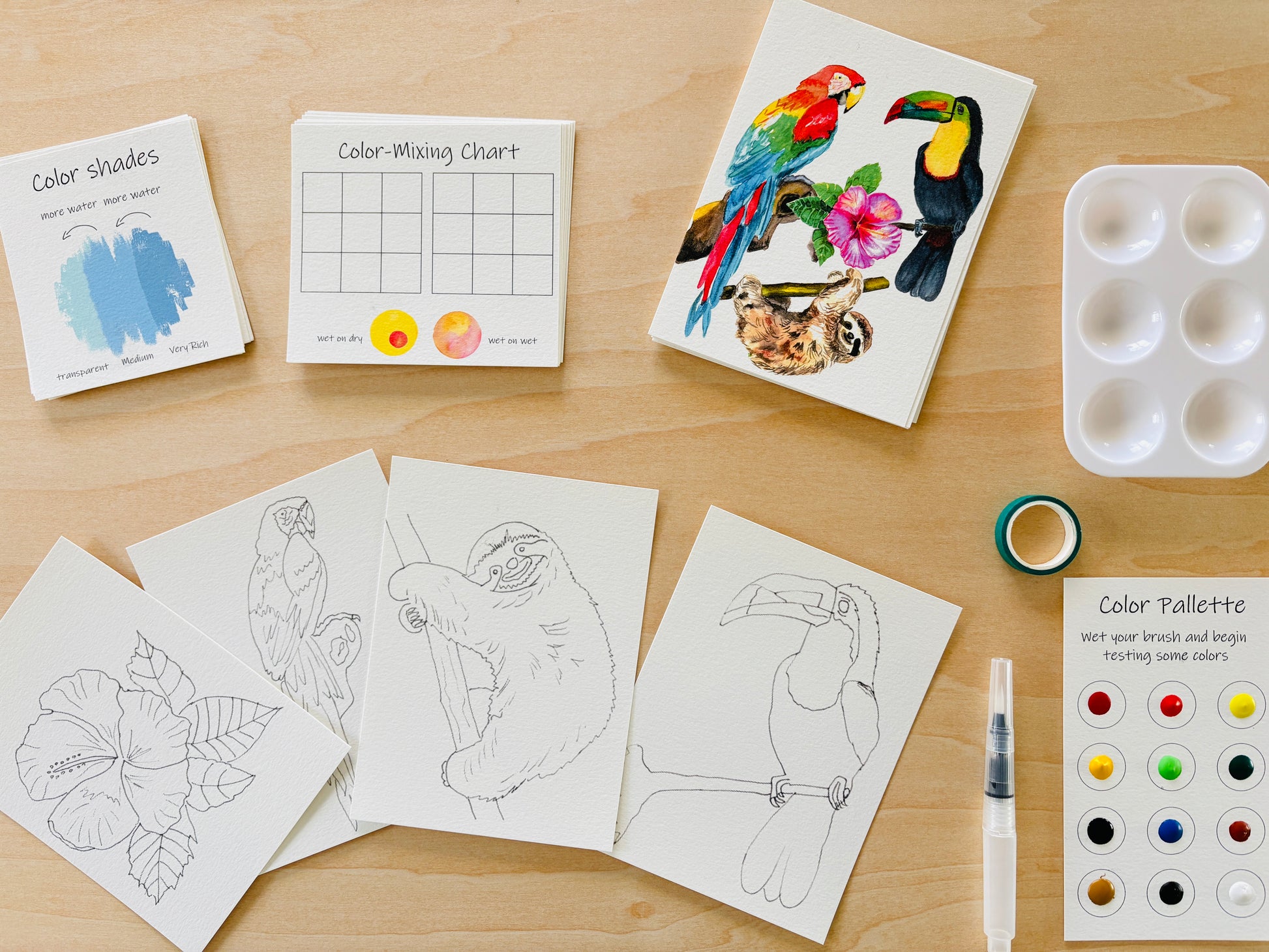 Watercolors Mini kit , charts, and art supplies on a wooden surface