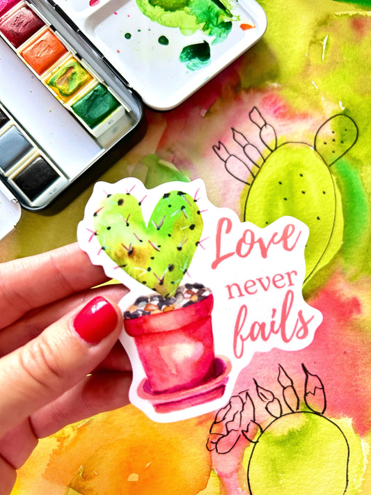 Cactus heart vinyl sticker with “Love Never Fails” phrase, nature-inspired watercolor design