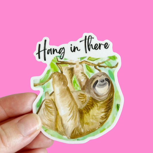 Sticker of a sloth with 'Hang in there' text on a pink background